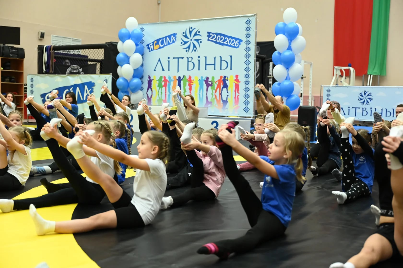 Дети выполняют упражнение на растяжку на празднике клуба ЛІТВІНЫ